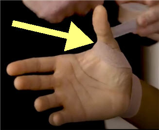 extending the tape from the wrist to wrap around the base of thumb