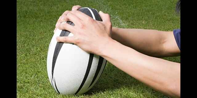 players hands touching a ball down for a try