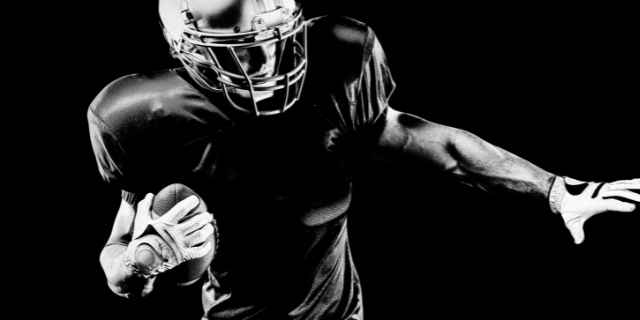 nfl player holding ball in black and white