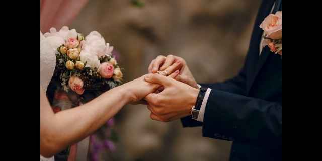 groom putting ring on brides finger